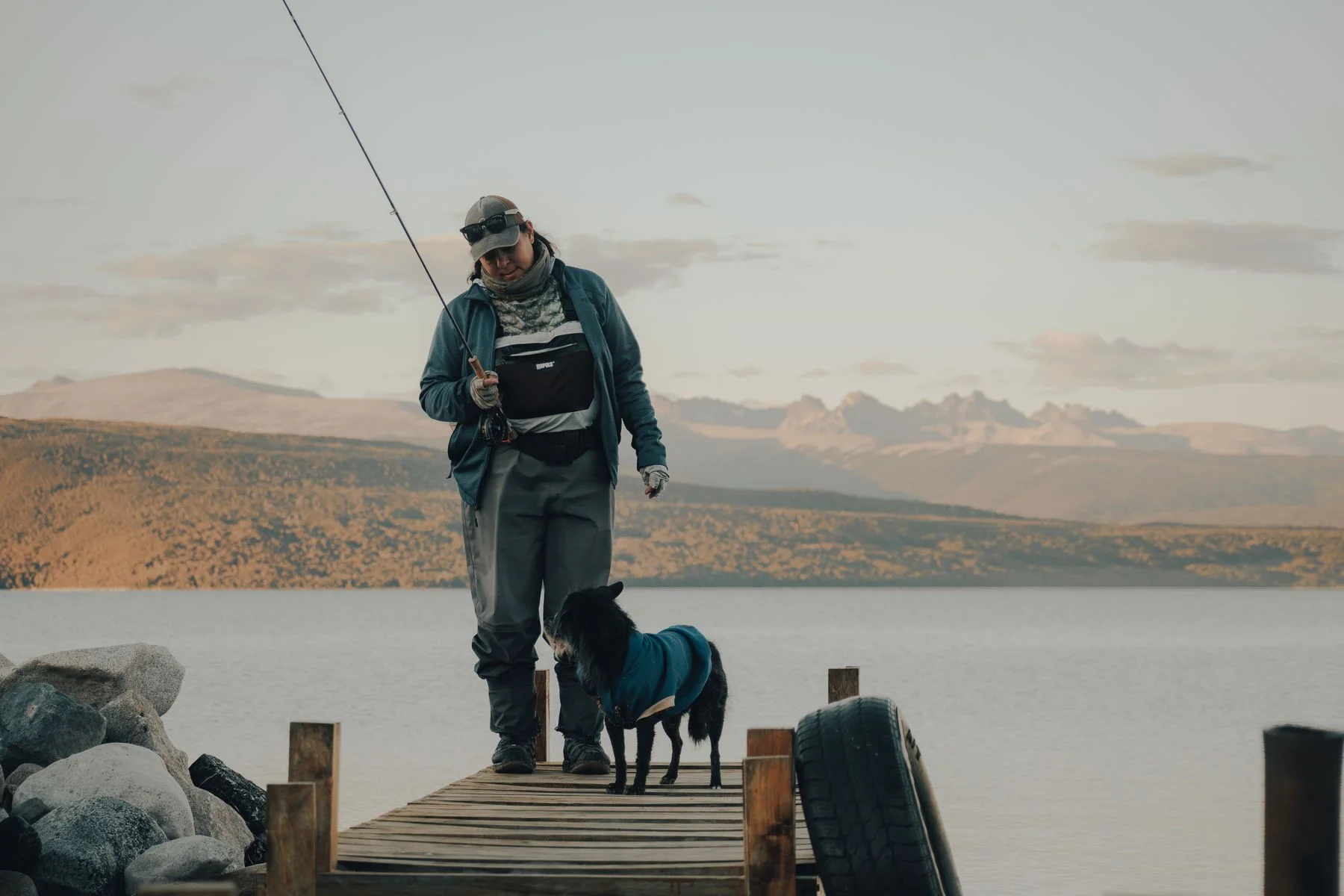 Angler and dog on a wooden pier