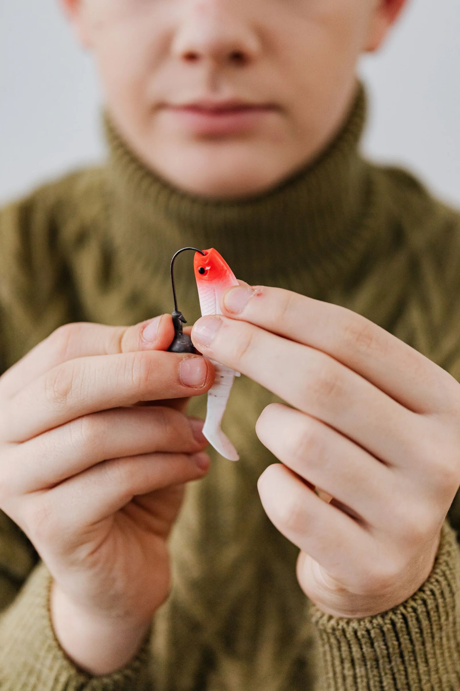 Hands inspecting a fishing lure