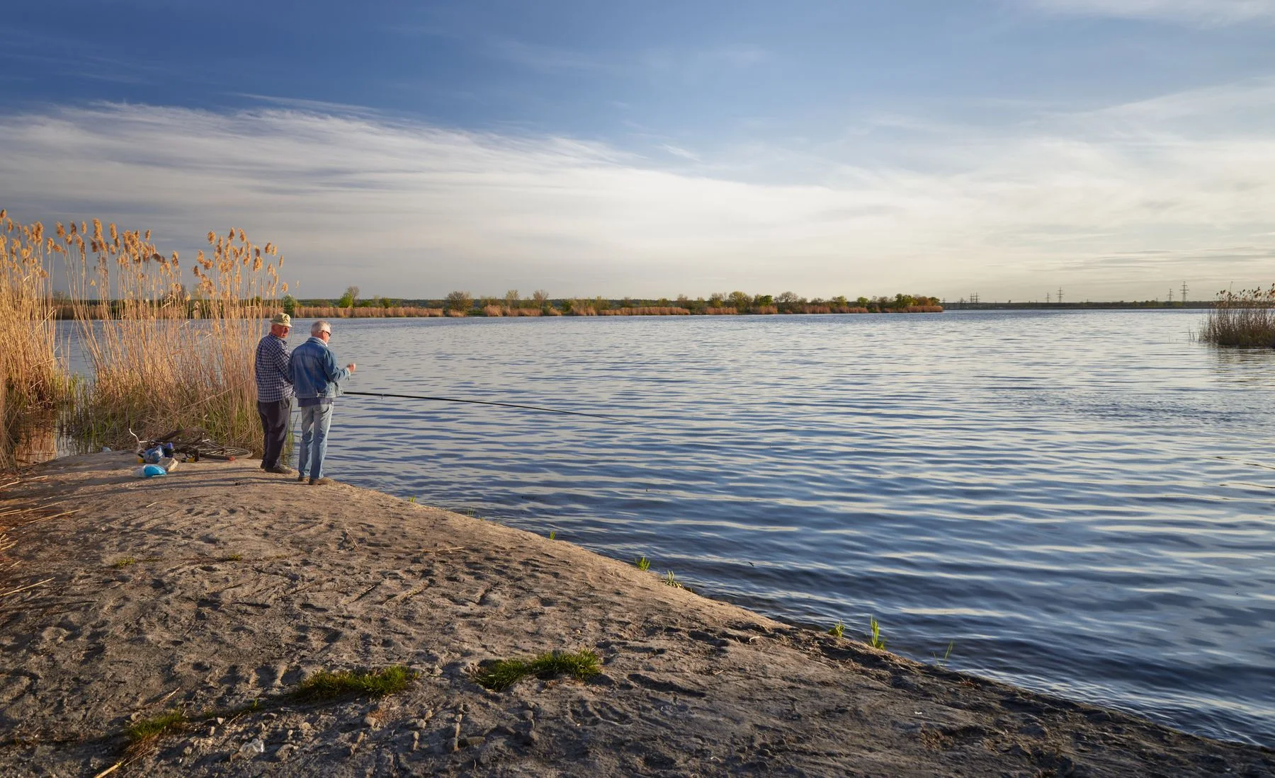Two anglers beside a lake